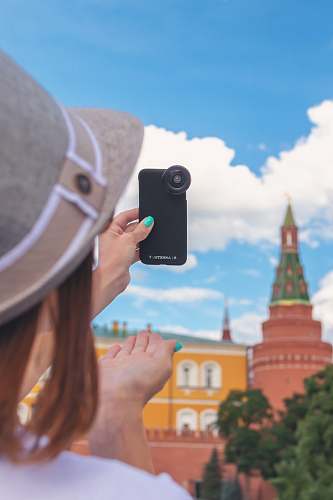 electronics person taking photo on multicolored castle under blue and white skies mobile phone